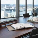 Ein großer Konferenztisch mit Modellen eines Frachtschiffs und einer Windkraftanlage vor einer Osloer Stadtsilhouette.